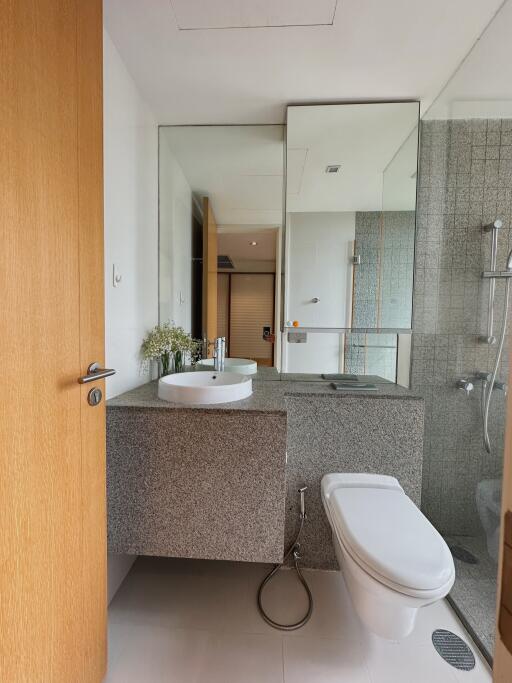 Modern bathroom interior with sink, floating vanity, mirror, toilet and shower