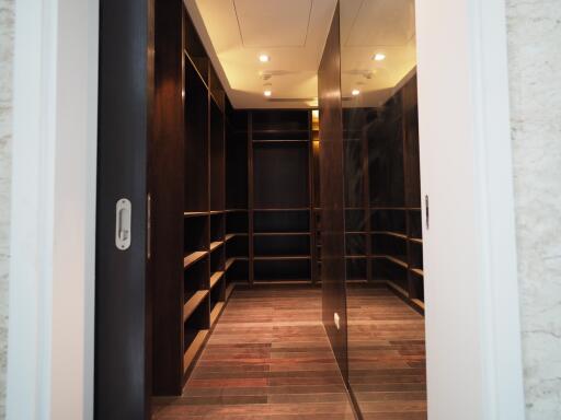 Spacious walk-in closet with wooden shelves and LED lighting