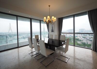 Modern dining room with glass windows offering a stunning city and river view