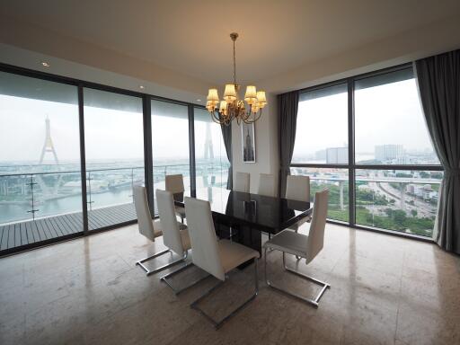 Modern dining room with glass windows offering a stunning city and river view