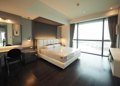 Spacious bedroom with large window and modern furnishings