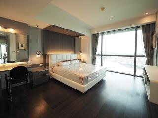 Spacious bedroom with large window and modern furnishings