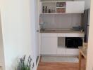 Modern kitchen with white cabinetry and wooden flooring