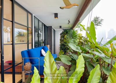 Modern balcony with blue sofa and lush green plants