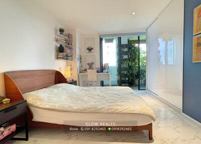 Spacious and modern bedroom with a desk, large bed, and balcony access