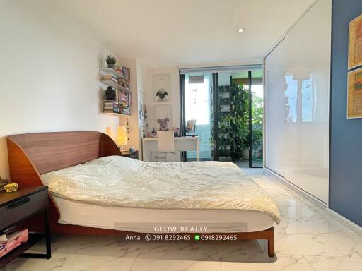 Spacious and modern bedroom with a desk, large bed, and balcony access