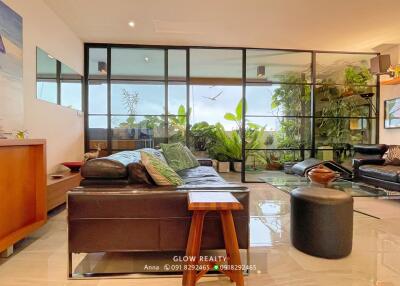 Spacious living room with large windows and indoor plants