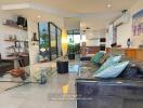 Modern living room with glass coffee table and black leather sofa