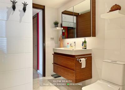 Modern bathroom with wooden accents and wall-mounted sink