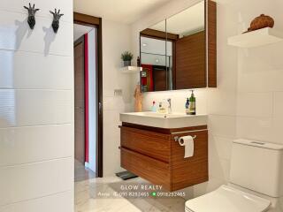 Modern bathroom with wooden accents and wall-mounted sink