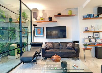 Modern living room with black sofa and glass wall