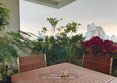 Outdoor dining area with plants and city view