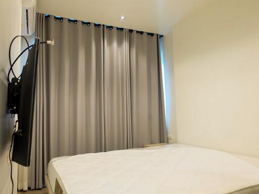 bedroom with curtains and wall-mounted TV
