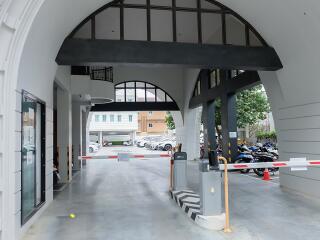 Covered building entrance with parking and security gate