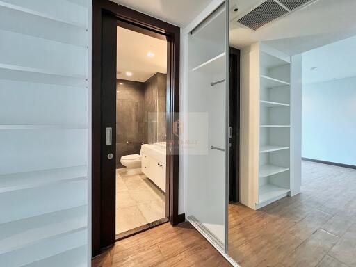 Modern bathroom with shower and white cabinetry, adjacent to living space