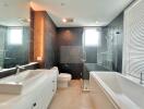 Modern bathroom with dual sinks, bathtub, glass shower, and large window