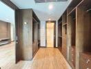 large walk-in closet with wooden shelves and drawers