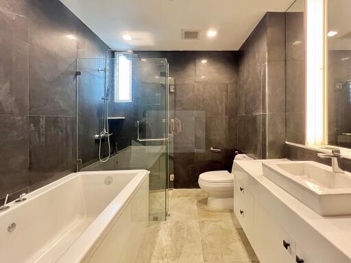 Modern bathroom with bathtub, shower, sink, and toilet