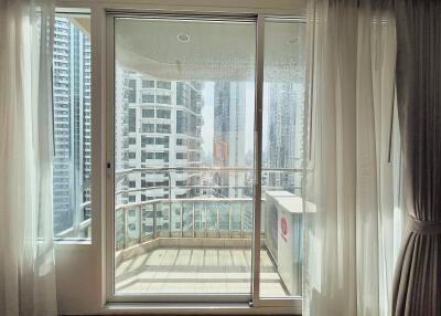 View of a modern balcony with floor-to-ceiling windows and cityscape backdrop