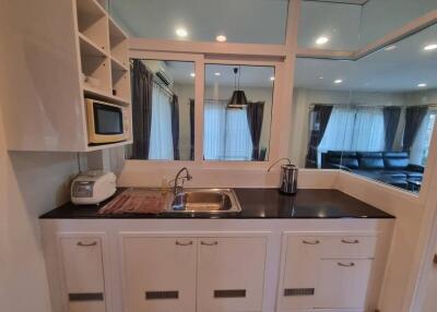 Modern kitchen with white cabinetry and a black countertop