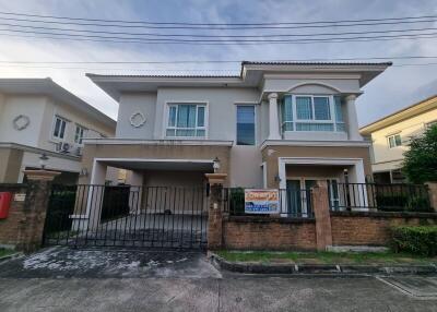 Front view of a modern two-story house with a gated driveway