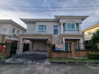 Front view of a modern two-story house with a gated driveway