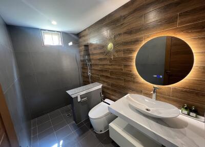 Modern bathroom with wooden accent wall and contemporary fixtures