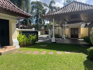 Well-maintained yard with a traditional-style open pavilion and lush greenery