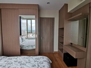 Modern bedroom with large window and built-in wardrobe