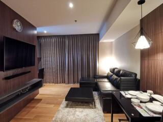 Modern living room with a black leather sofa and a flat-screen TV