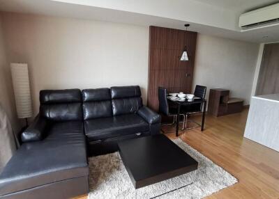 modern living room with black leather sofa and dining area