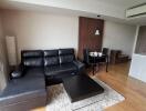 modern living room with black leather sofa and dining area