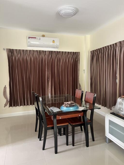 Dining room with a glass-top table, six chairs, brown curtains, and air conditioning