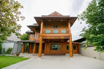 Wooden exterior of a two-story house with surrounding greenery