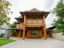 Wooden exterior of a two-story house with surrounding greenery