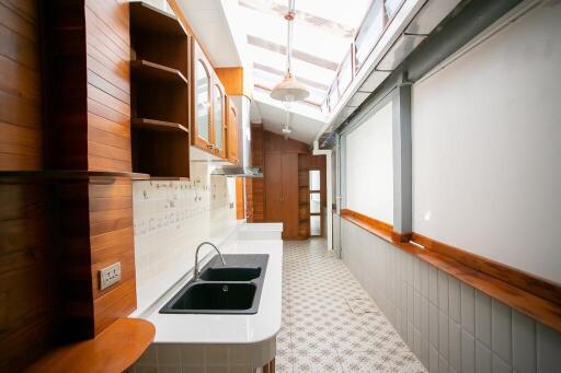 Bright, modern kitchen with wooden cabinets and two sinks