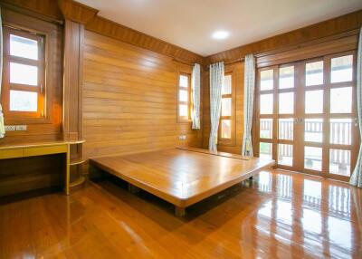 Spacious wooden bedroom with large windows and platform bed