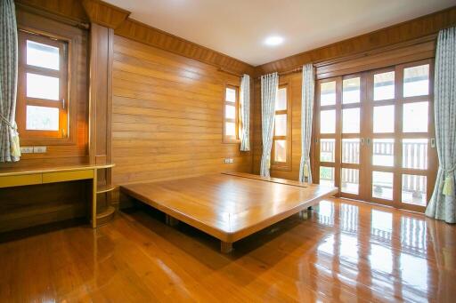 Spacious wooden bedroom with large windows and platform bed