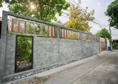 Exterior view of the property with a concrete fence and a gate