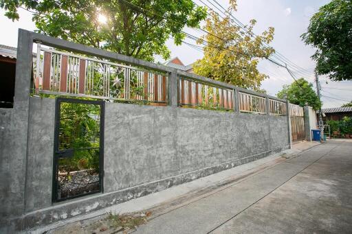 Exterior view of the property with a concrete fence and a gate