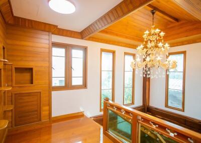 Elegant stairway landing with wooden finishes and chandelier