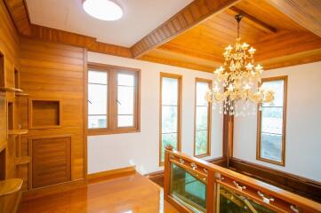 Elegant stairway landing with wooden finishes and chandelier