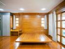 Spacious wooden bedroom with high ceiling and large windows