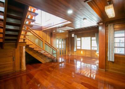 Spacious wooden living area with staircase and large windows