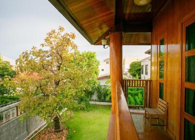 Cozy balcony overlooking garden with wooden furniture