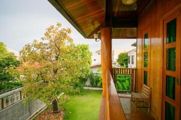 Cozy balcony overlooking garden with wooden furniture