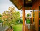 Cozy balcony overlooking garden with wooden furniture