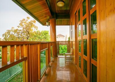 Wooden balcony with glass railing and outdoor seating