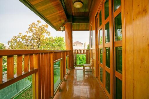 Wooden balcony with glass railing and outdoor seating