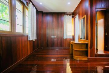 Spacious wooden bedroom with large windows and vanity